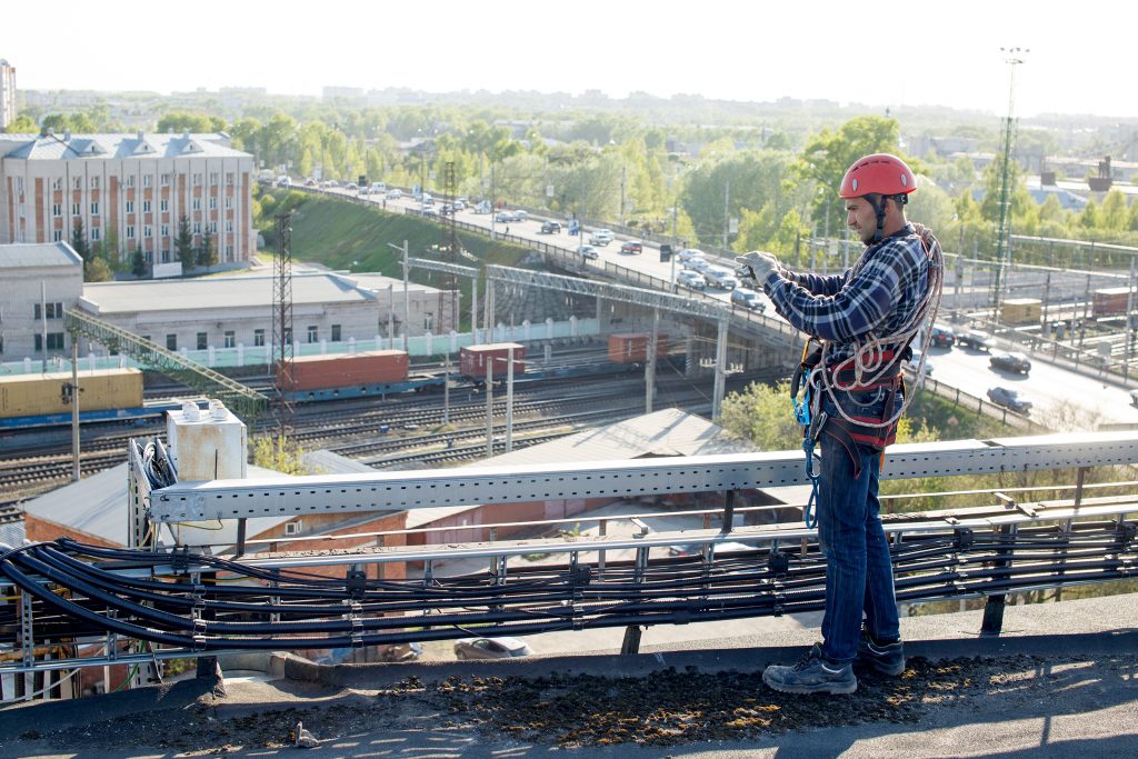 worker finished work and takes photos for the report. tower technician installed telecommunication equipment on the roof of the building.