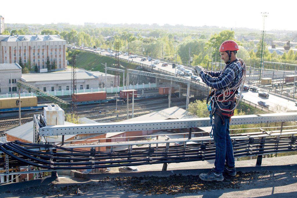 worker finished work and takes photos for the report. tower technician installed telecommunication equipment on the roof of the building.